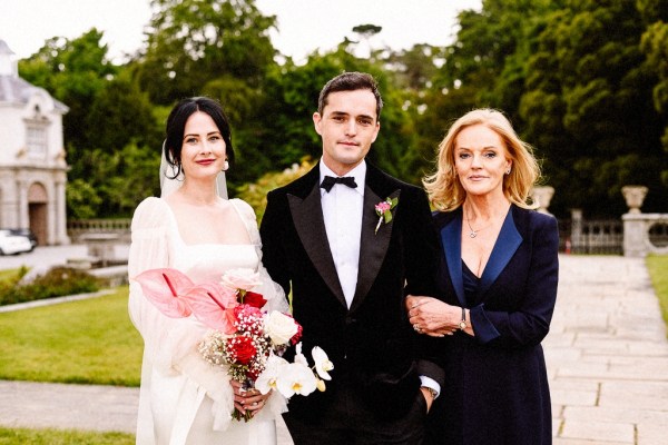 Bride groom and mother pose for a picture