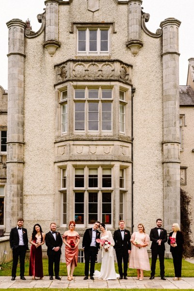 Bride groom bridesmaids groomsmen family pose for a picture