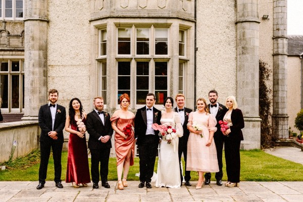 Bride groom bridesmaids groomsmen family pose for a picture