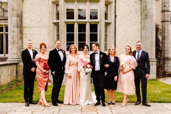 Bride groom bridesmaids groomsmen family pose for a picture