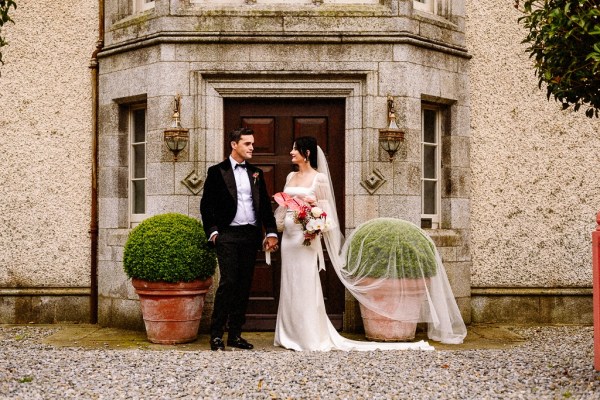 Couple bride groom looking at each other exterior wedding venue front door