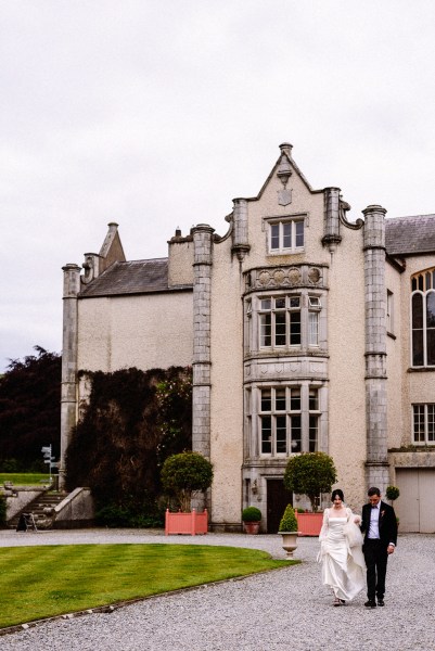 Exterior wedding venue couple walking on pavement