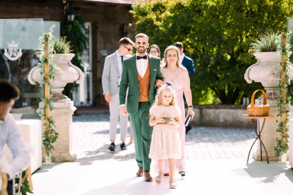 Groom woman and little girl walk towards ceremony