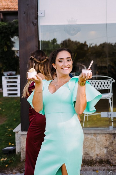 Woman in green smiles with ice cream in hand