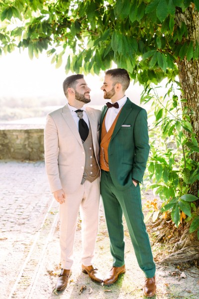 Grooms look at each other in garden