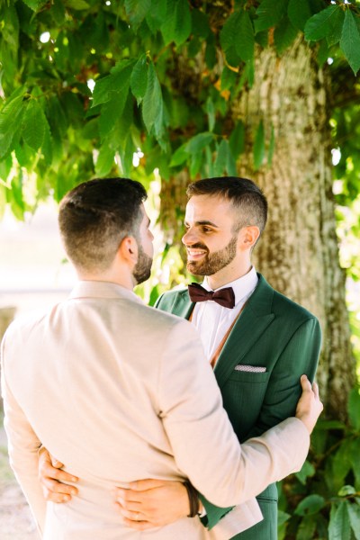 Grooms look at each other in garden