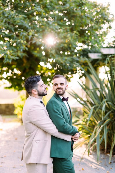 Groom over the shoulder looking at groom hugging