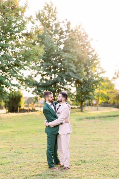 Grooms hug each other embrace in garden