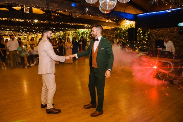 Grooms dance on dancefloor together