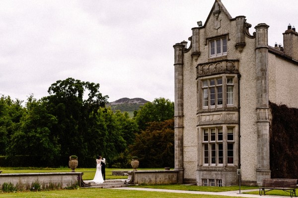 Wide shot of couple exterior shot outside wedding venue castle