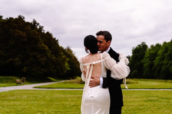 Bride and groom hug embrace on garden in grass