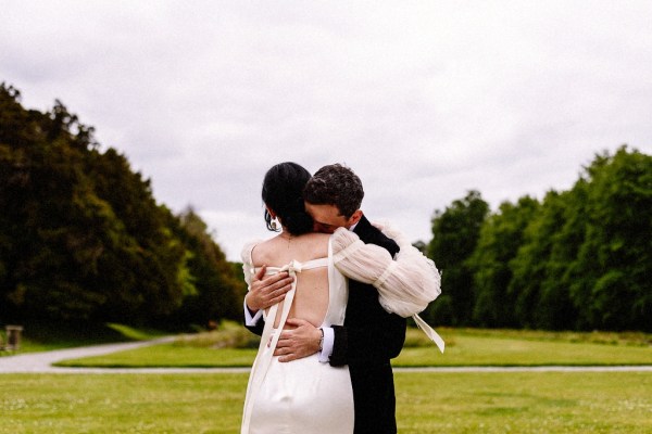 Bride and groom hug embrace on garden in grass