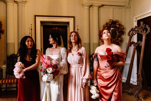 Interior shot of bridesmaids and bride on red carpet rug stately home interior setting