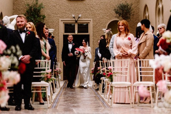 Bride walks up with aisle guests wait