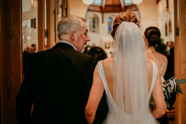 Father of the bride walks down the aisle smiling