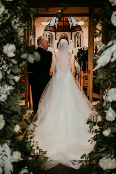 Father of the bride walks down the aisle smiling