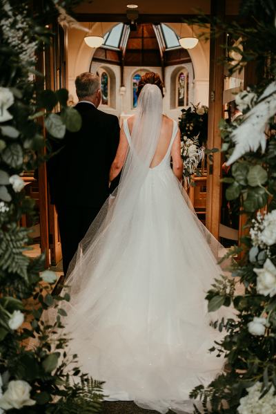 Father of the bride walks down the aisle smiling