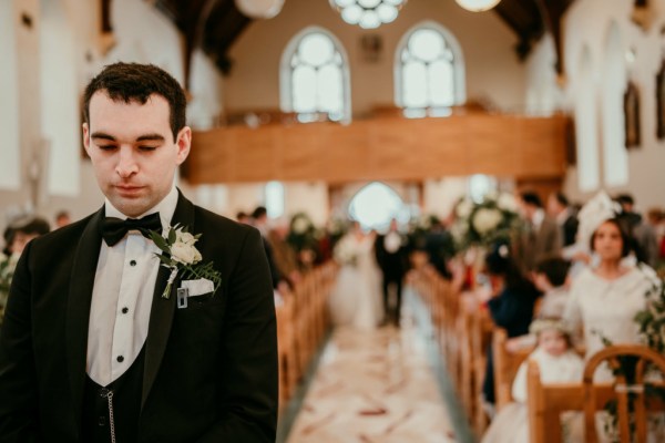 Father of the bride walks down the aisle smiling grooms waits at alter