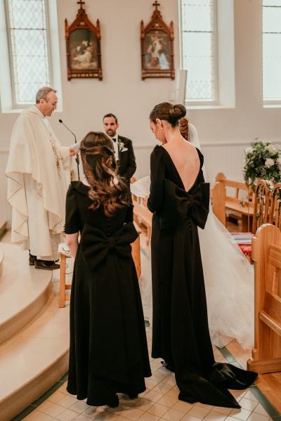 Bride and groom and bridesmaids and priest at alter