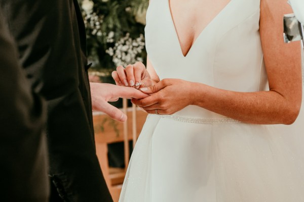 Bride and groom exchange rings bands