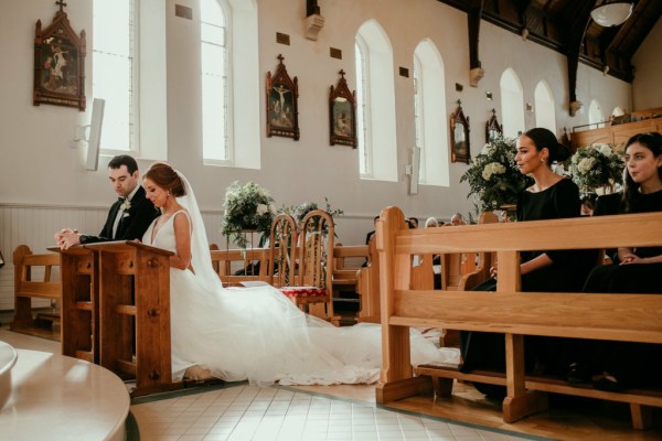 Bride and groom together kneeling during church ceremony