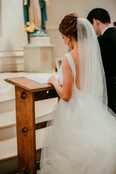 Bride and groom together kneeling during church ceremony