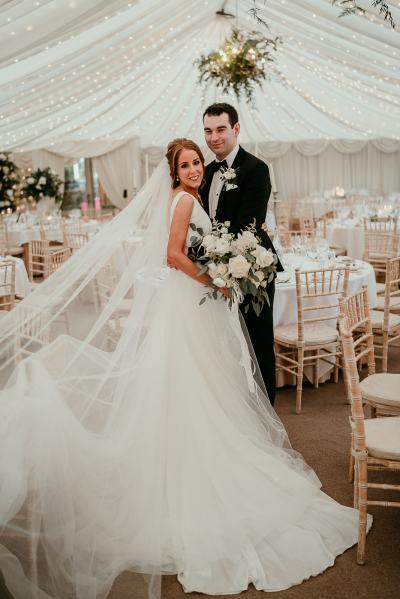 Bride and groom enter empty dining room ballroom setting