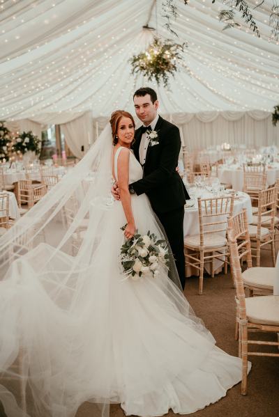 Bride and groom enter empty dining room ballroom setting