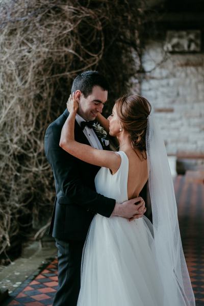 Bride puts her hands on grooms face laughing smiling together