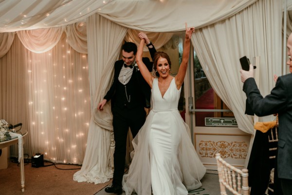 Bride and groom enter ballroom hands in the air