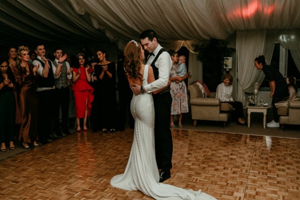 Bride and groom dancing on the dancefloor surrounded by guests