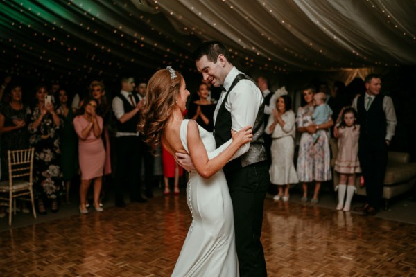 Bride and groom dancing on the dancefloor surrounded by guests