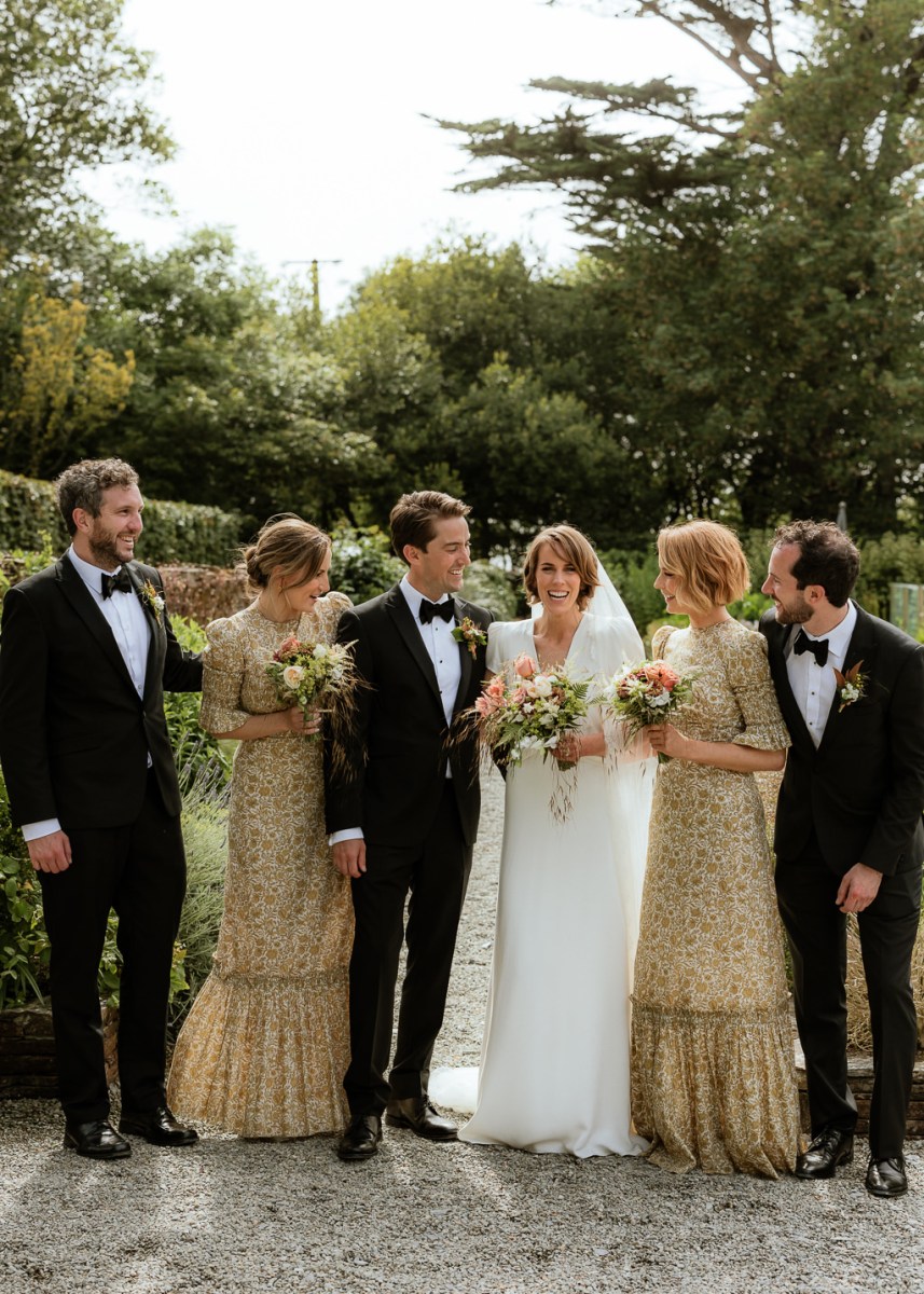 Bride groom bridesmaids and groomsmen pose for a picture