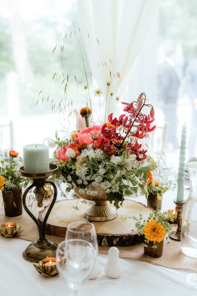 Bouquet of flowers and candles on wooden plaque frame table