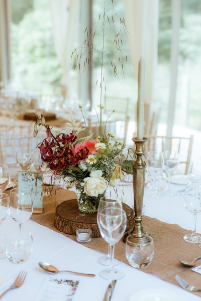 Flowers candles roses and glasses on table