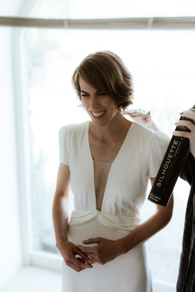 Bride getting hairspray in hair