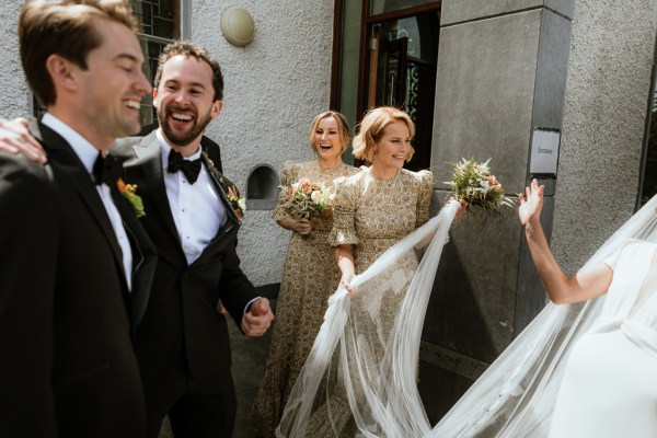 Bridesmaids and groom/groomsmen smile and celebrate