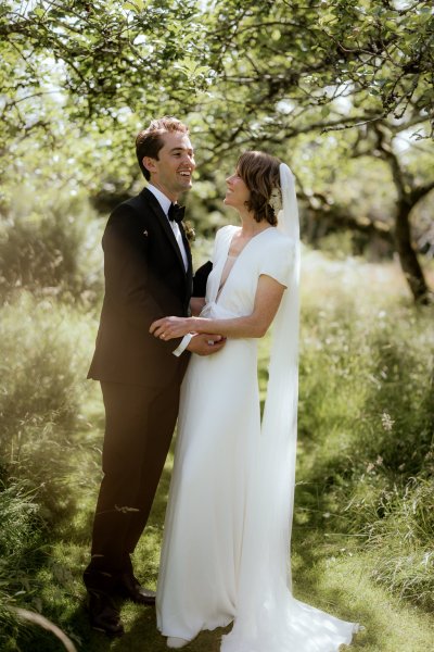 Bride and groom look at each other as they pose for the camera