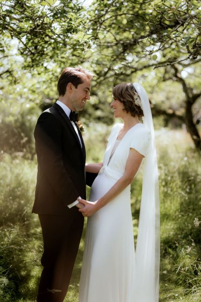 Bride and groom look at each other as they pose for the camera