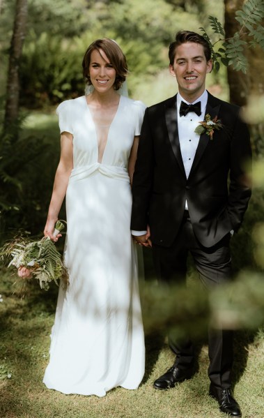 Bride and groom pose on the grass