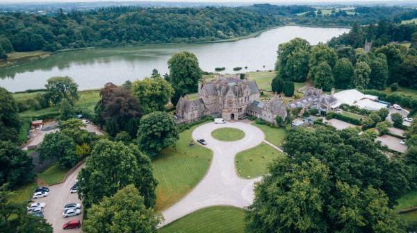 Exterior wideshot of lake and wedding venue forest setting drone view