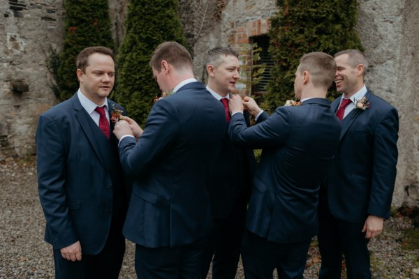 Groom and groomsmen walk along pavement