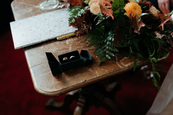 Wedding box containing bands/rings beside flowers