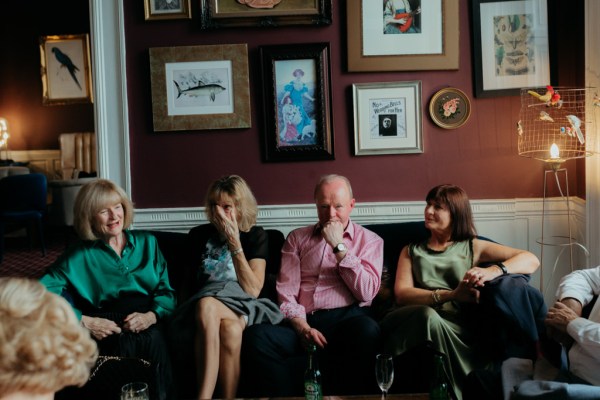 Guests three women and one man sit on couch