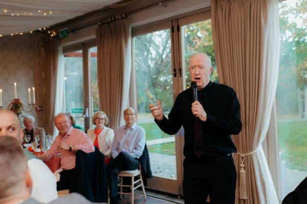 Father gives speech to guests man with microphone