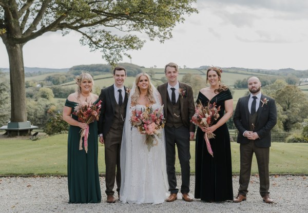 Bride bridesmaids groom and groomsmen pose for a picture