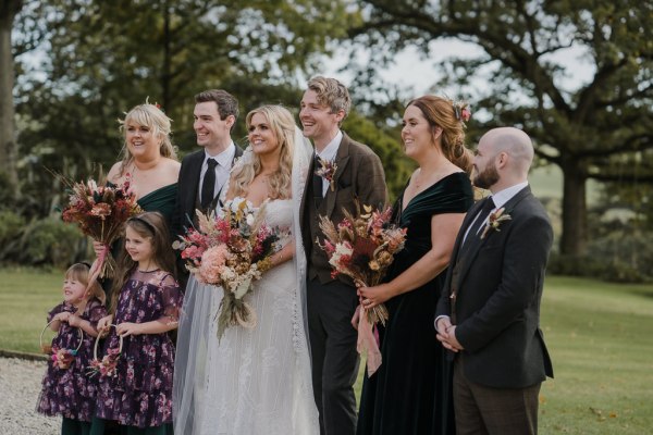 Bride bridesmaids groom and groomsmen pose for a picture