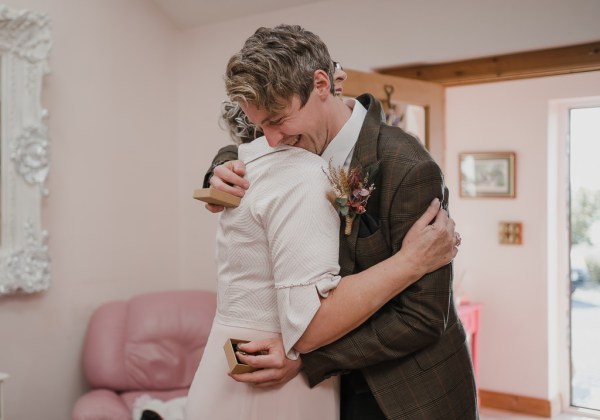 Groom holds brown box and hugs mother