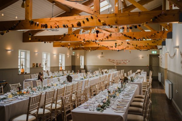 Empty dining room ballroom flowers candles and glasses on table