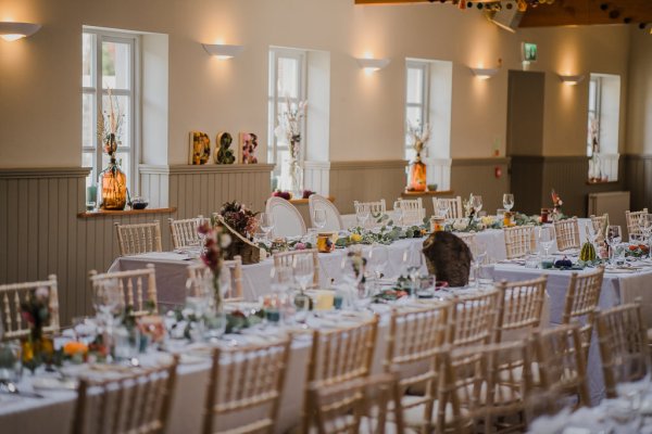 Empty dining room ballroom flowers candles and glasses on table